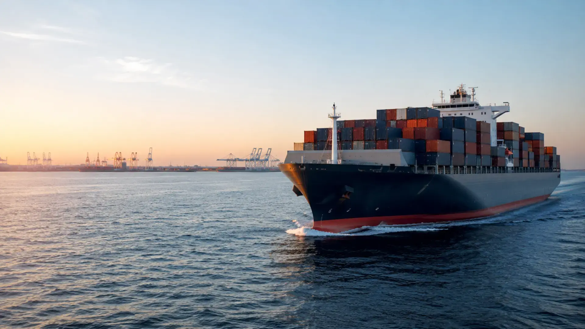 Container vessel approaching an international port at sunrise